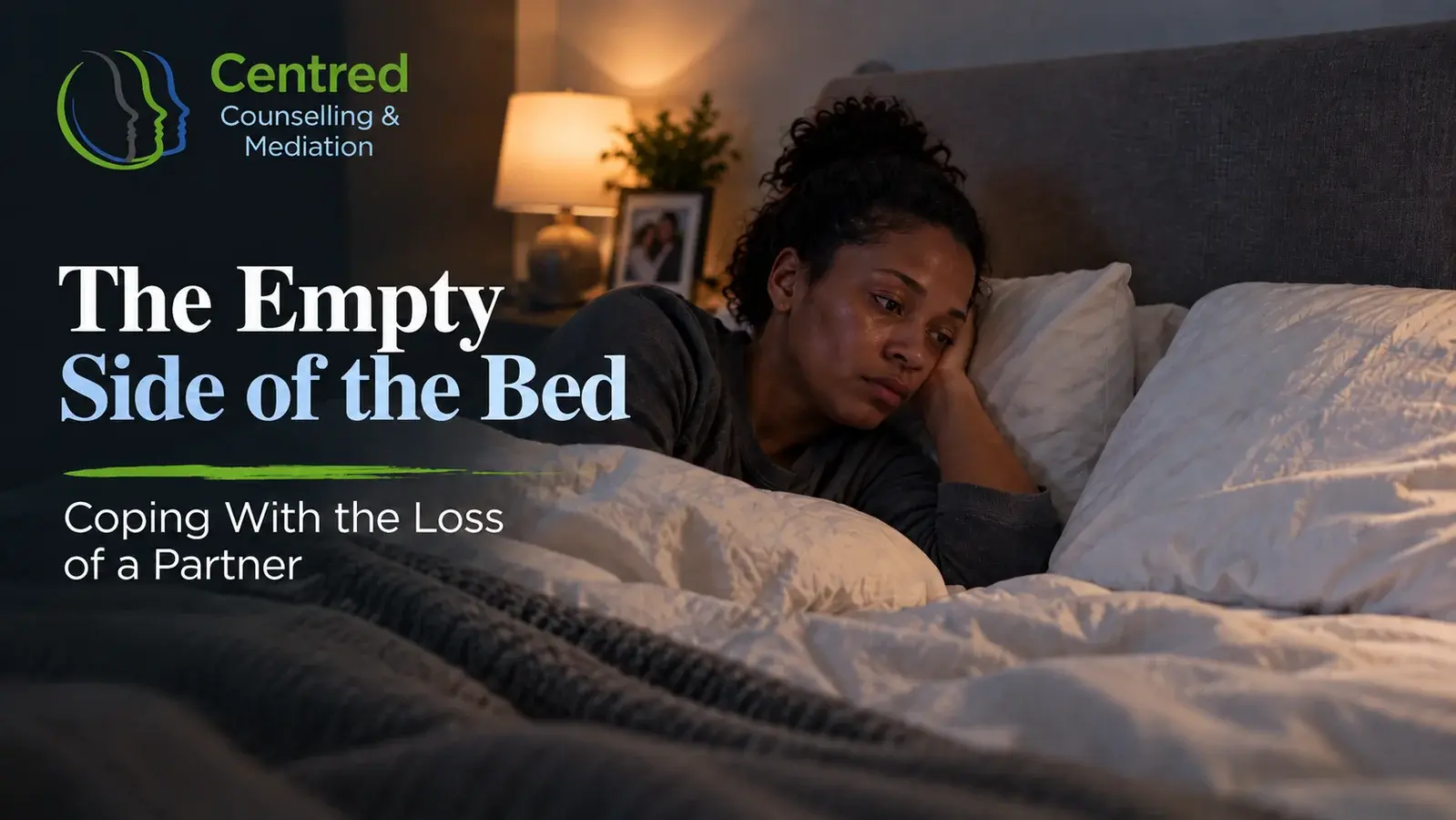 An empty side of a double bed with a pillow and neatly folded bedding.